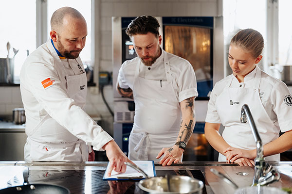 Ludwig Tjörnemo i köket tillsammans med XX och commis Emilia Björklund.