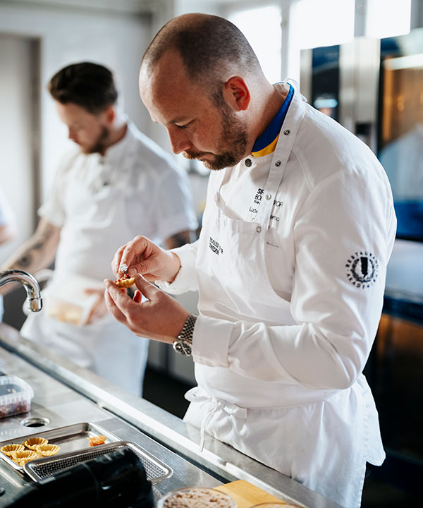 Ludwig Tjörnemo stod för menyn under inspelningen av Menigos samtalsserie Länge leve måltiden. Bild 1. Varmrätt - Färserad kyckling med kål och grillat äpple. Bild 3: Karamelliserat äpple med punsch och blodapelsin.   