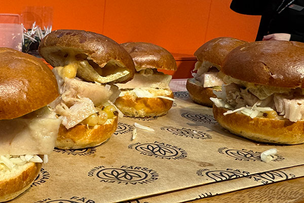 Confiterad fläsksida, krispig svål, rostad jordnötsmajo & picklade vinbär i sliderbröd.