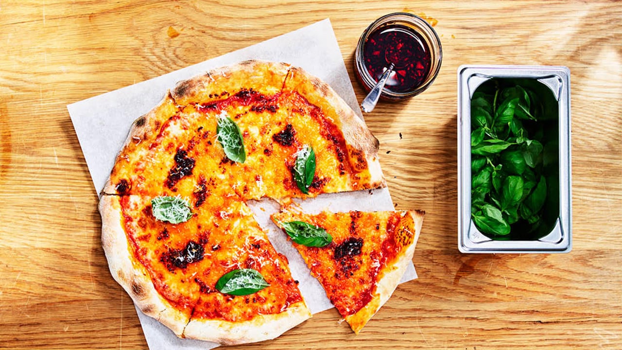 pizza med tillbehör på bord