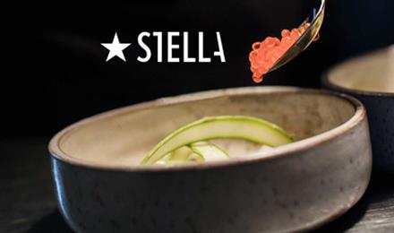 Namnet Stella syns över en tallrik som får orange kaviar serverat med en sked
